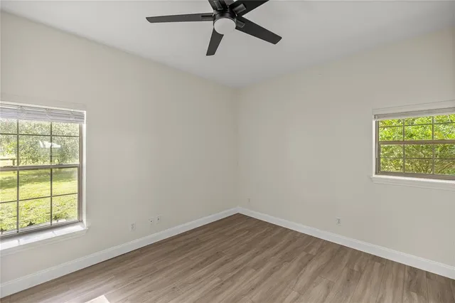 a view of a livingroom with wooden floor and a ceiling fan