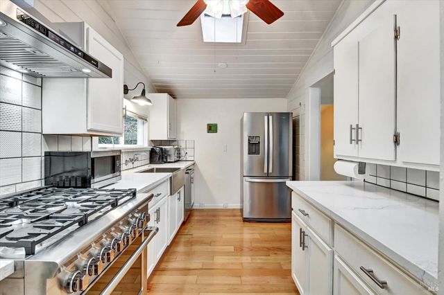 a kitchen with kitchen island a sink stove and refrigerator