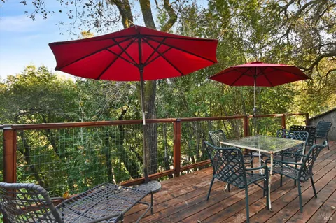 a view of a balcony with chairs and an umbrella