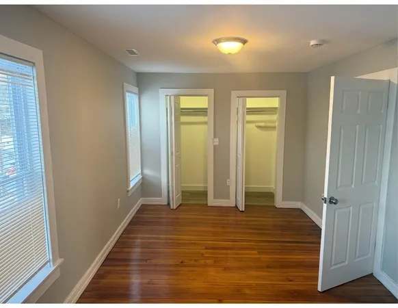 a view of a room with wooden floor and a bathroom