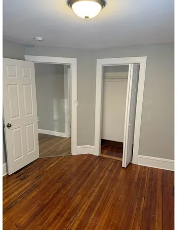 an empty room with wooden floor and closet