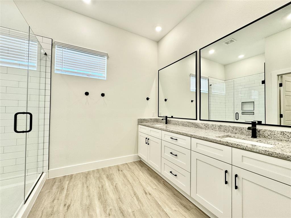 8513 Shorehan Road The Colony, TX 75056 - Photo 11 of 25 Bathroom featuring wood finished floors, plenty of natural light, a shower stall, and recessed lighting