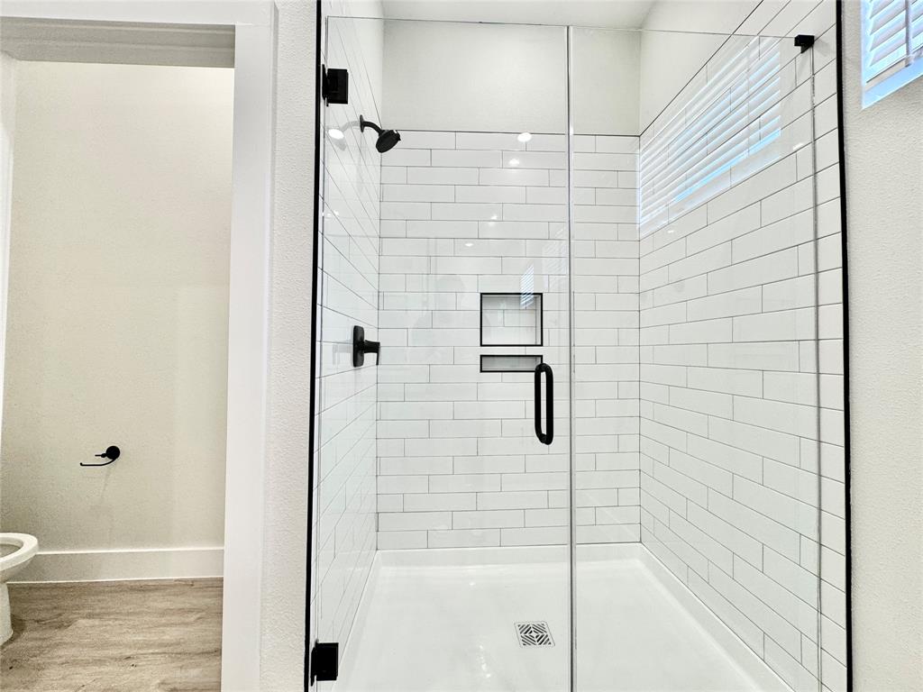 8513 Shorehan Road The Colony, TX 75056 - Photo 12 of 25 Bathroom with wood finished floors, a shower stall, toilet, and baseboards