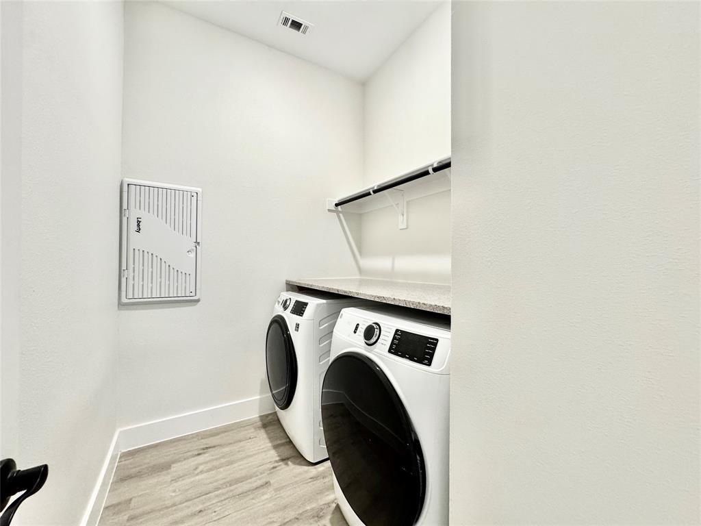 8513 Shorehan Road The Colony, TX 75056 - Photo 13 of 25 Clothes washing area with washer and dryer, light wood finished floors, and baseboards
