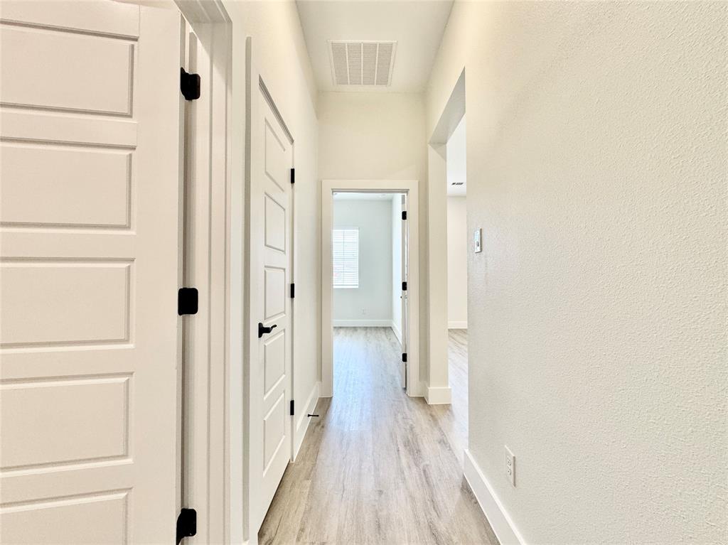 8513 Shorehan Road The Colony, TX 75056 - Photo 18 of 25 Corridor featuring light wood-style floors and baseboards