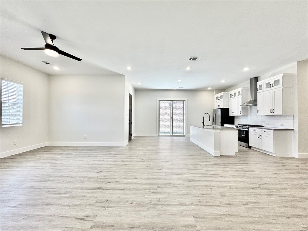 8513 Shorehan Road The Colony, TX 75056 - Photo 3 of 25 Unfurnished living room featuring a sink, light wood-style floors, baseboards, ceiling fan, and recessed lighting