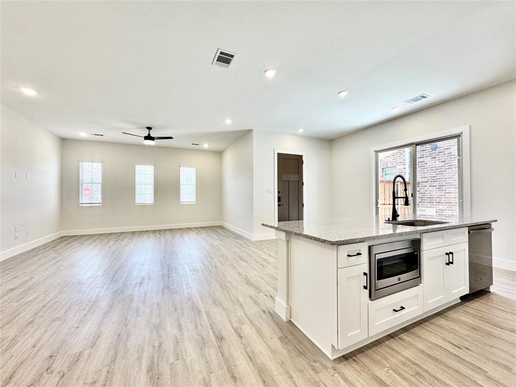 8513 Shorehan Road The Colony, TX 75056 - Photo 6 of 25 Kitchen with a sink, appliances with stainless steel finishes, plenty of natural light, baseboards, and recessed lighting