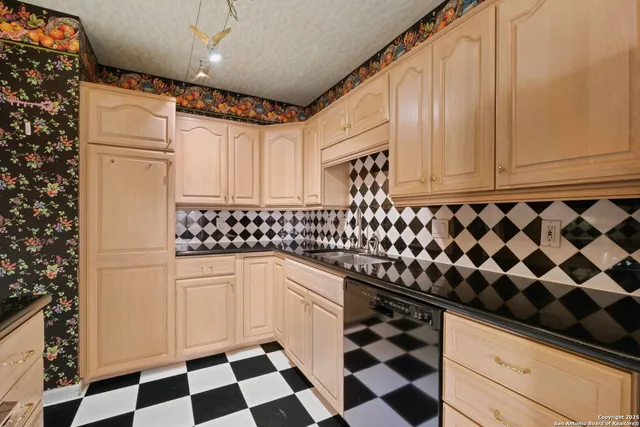 a kitchen with granite countertop white cabinets and black appliances
