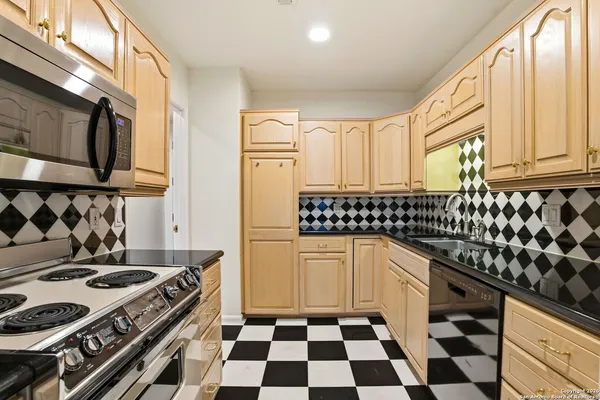 a kitchen with a stove a sink and a refrigerator