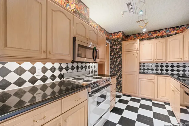 a kitchen with granite countertop cabinets and appliances