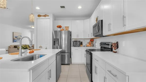 a kitchen filled with stainless steel appliances a sink a refrigerator and cabinets