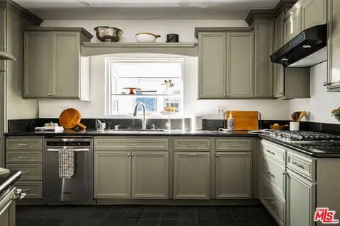 a kitchen with stainless steel appliances granite countertop a sink stove and cabinets