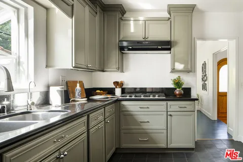 a kitchen with granite countertop a sink and cabinets