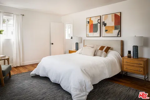 a bedroom with a bed and painting on the wall