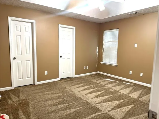 en empty room with a window and a ceiling fan