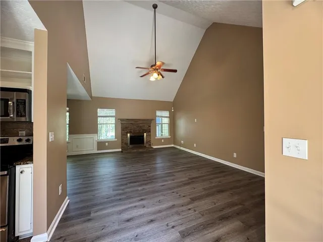 a view of empty room with wooden floor and fireplace