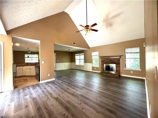 a view of an empty room with a fireplace and a window