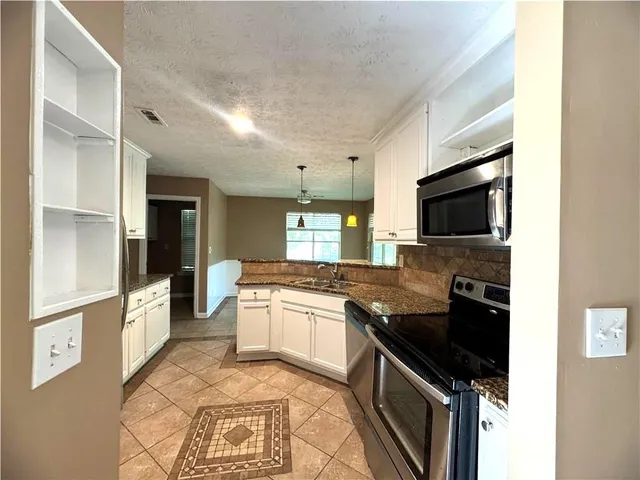 a kitchen with stainless steel appliances granite countertop a stove and a microwave