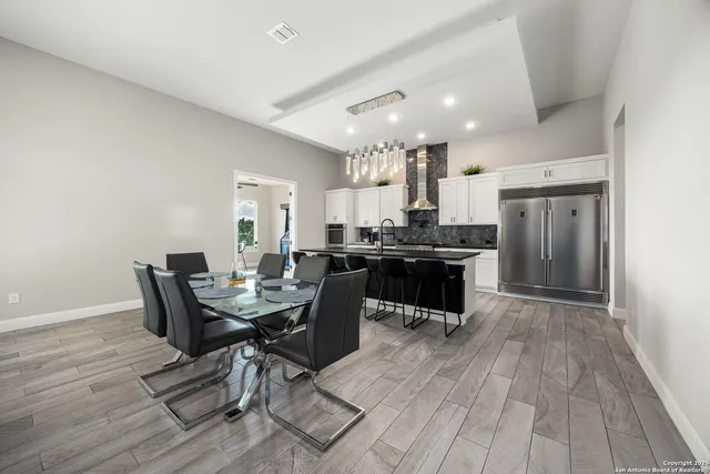 a kitchen with a table chairs a sink dishwasher stove and cabinets with wooden floor