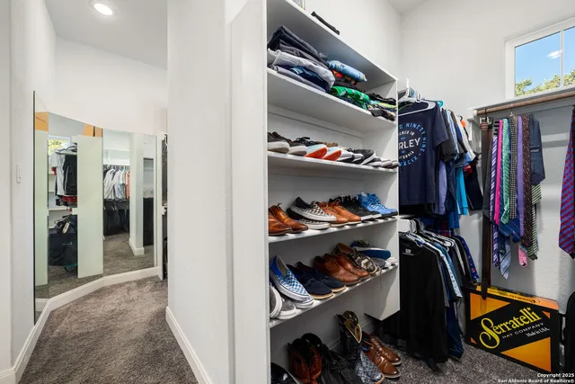 a view of walk in closet with clothes and shoes