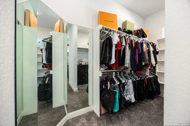 a view of walk in closet with clothes and shoes
