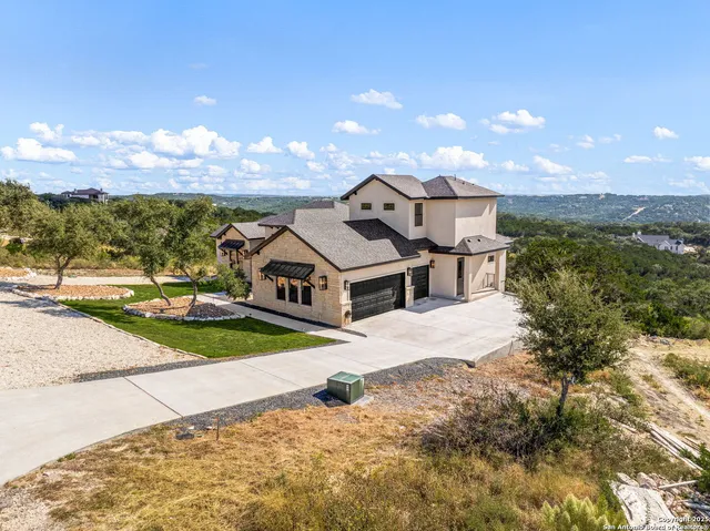 a view of a house with a yard and potted plants