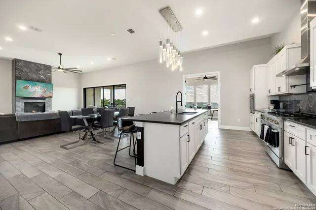 a large white kitchen with stainless steel appliances kitchen island