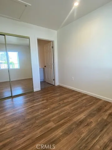 an empty room with wooden floor and mirror