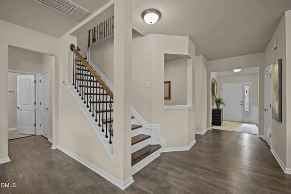 a view of a hallway with entryway wooden floor and stairs