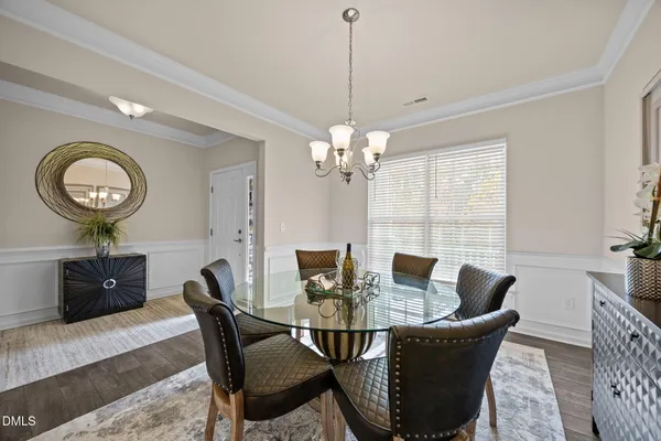 a view of a dining room with furniture a chandelier and wooden floor