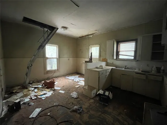 a room with a couch wooden floor and windows