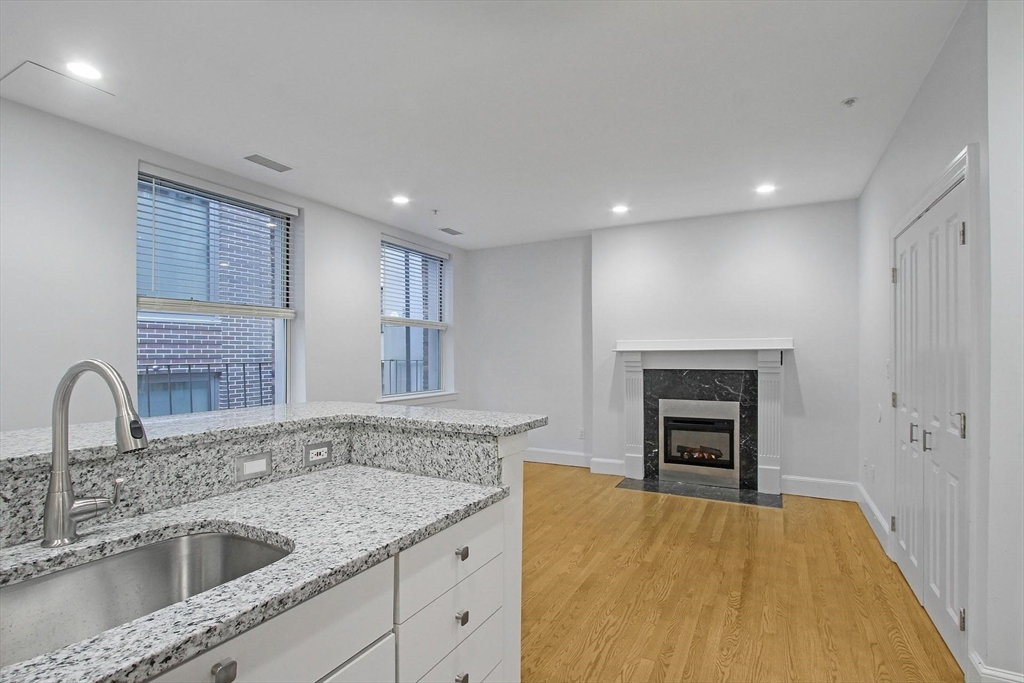 140 Boylston Street, Unit 10 Boston, MA 02116 - Photo 11 of 14 a kitchen with a sink and a fireplace
