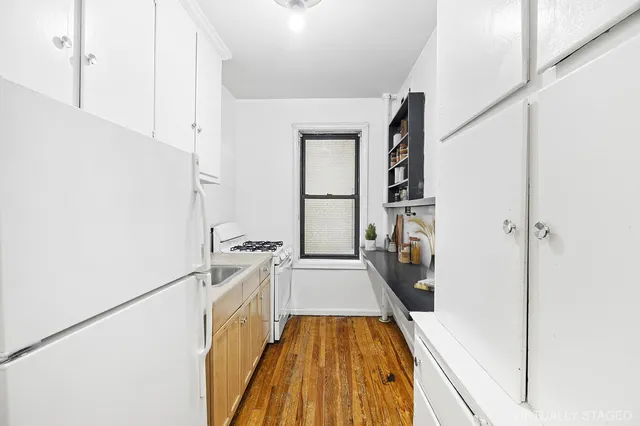a view of a kitchen with a sink and refrigerator