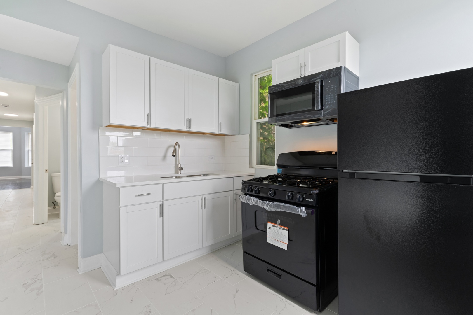 4718 West Monroe Street Chicago, IL 60644 - Photo 7 of 13 a kitchen with a stove microwave and sink