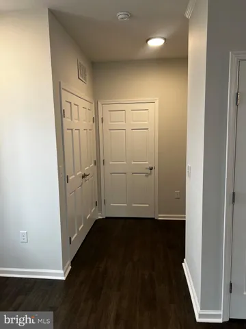 an empty room with wooden floor and cabinet