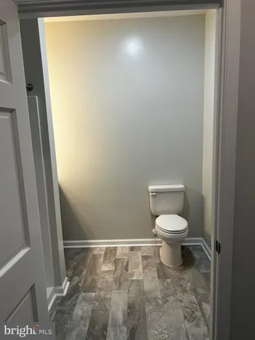 a white toilet sitting next to a shower