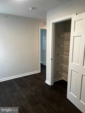 an empty room with wooden floor and entrance