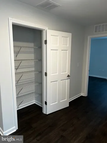 an empty room with wooden floor and closet