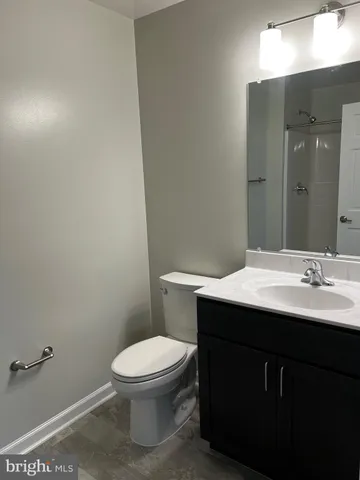 a bathroom with a sink a toilet a mirror and vanity