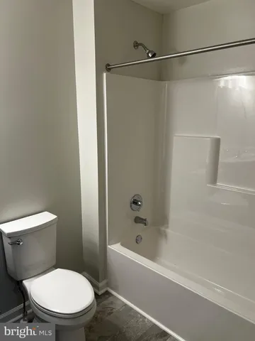 a white toilet sitting next to a bath tub and a shower