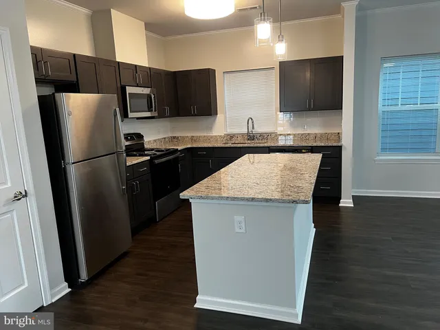 a kitchen with a refrigerator a microwave a sink and cabinets