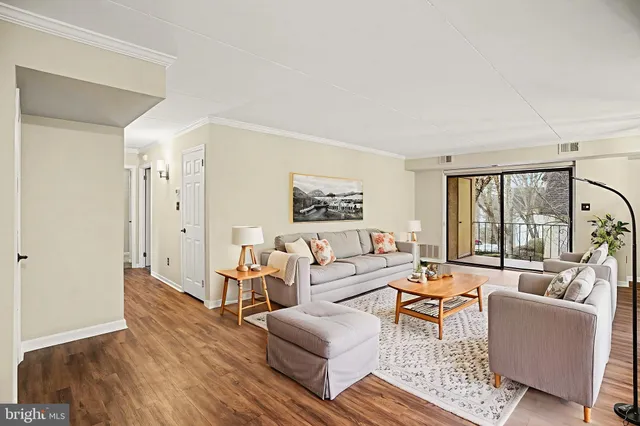 a living room with furniture large window and wooden floor