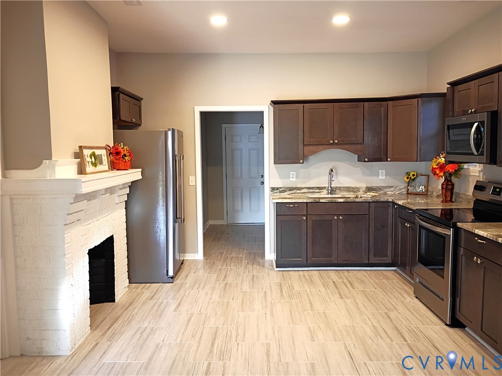 6103 Hermitage Road Henrico, VA 23228 - Photo 12 of 44 a kitchen with stainless steel appliances a stove top oven a sink and a refrigerator
