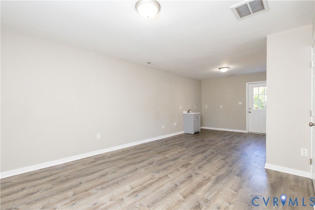 6103 Hermitage Road Henrico, VA 23228 - Photo 16 of 44 an empty room with wooden floor and windows