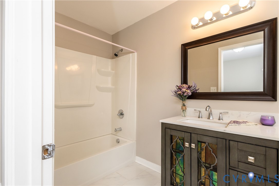 6103 Hermitage Road Henrico, VA 23228 - Photo 18 of 44 a bathroom with a sink a mirror and a bathtub