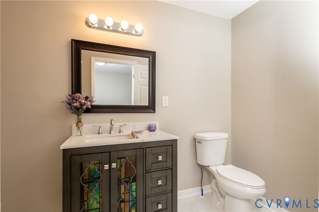 6103 Hermitage Road Henrico, VA 23228 - Photo 19 of 44 a bathroom with a toilet sink and mirror