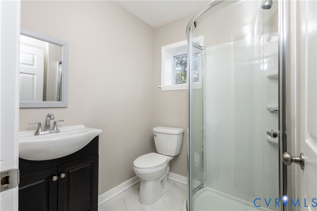 6103 Hermitage Road Henrico, VA 23228 - Photo 25 of 44 a bathroom with a toilet sink vanity and mirror