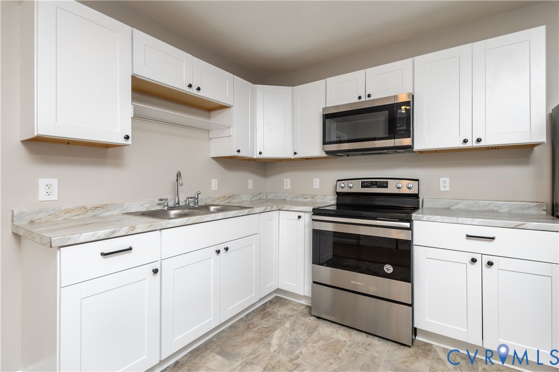 6103 Hermitage Road Henrico, VA 23228 - Photo 37 of 44 a kitchen with granite countertop white cabinets sink and stainless steel appliances