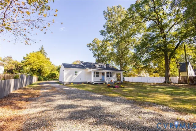 a view of a house with a big yard and large trees