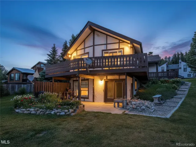a view of a house with brick walls and a yard with plants